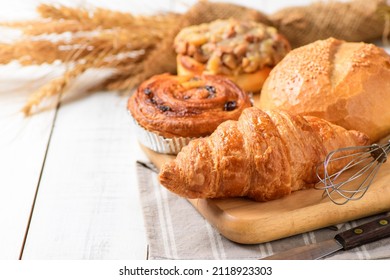 Croissant de mantequilla con Sourdough y bollería danesa con fondo de madera blanca, concepto de panadería casera