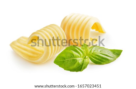 Butter curls or butter rolls with basil leaves isolated on white background