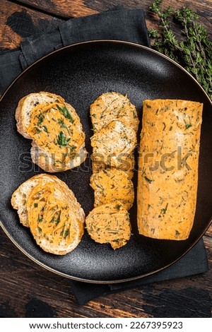 Butter with flavoring additives, sandwich butter with fresh herbs, sweet peppers, lemon, onion, garlic. Wooden background. Top view.