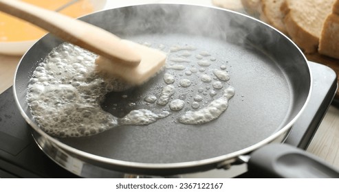 Butter in a hot frying pan. Bubbles and steam of melted butter. Cooking food. A series of photos of Bread with Egg Recipe.