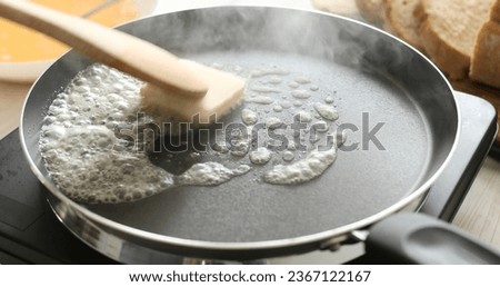 Butter in a hot frying pan. Bubbles and steam of melted butter. Cooking food. A series of photos of Bread with Egg Recipe.