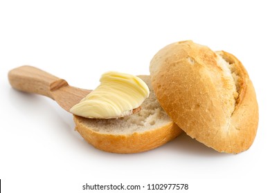 Butter On Wooden Knife Resting On A Cut Crusty Bread Roll Isolated On White.