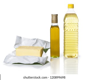 Масло в бумаге и две бутылки различных видов масла на белом фоне