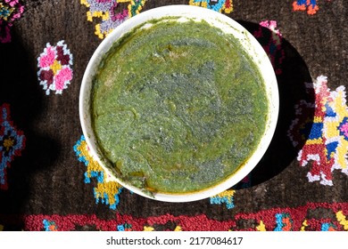 Butter Stinging Nettle Soup, Green  Nettle Of Spring On  Top View On Wool-colored Hand-knitted Background. Stinging Nettles (Urtica Dioica) In The Garden. Green Leaves With Serrated Edges.