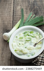 Buttered  creamy leek in ceramic bowl on wooden background 