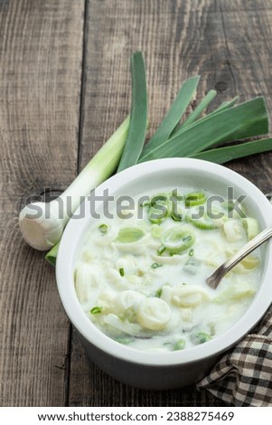 Buttered  creamy leek in ceramic bowl on wooden background 