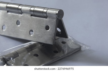 Butterfly door hinge with strong metal iron stainless steel material. Engsel kupu-kupu with four ball bearings. Industrial object equipment close up.