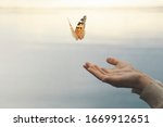 butterfly flies free from a woman