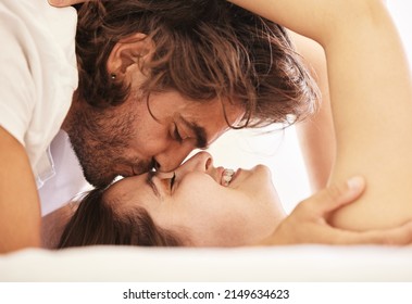 Butterfly Kisses. Shot Of A Young Couple Having An Intimate Moment On The Bed At Home.