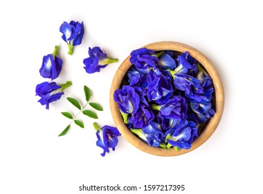 Butterfly pea or blue pea , bluebellvine, cordofan pea ( clitoria ternatea ) with green leaf in wooden bowl isolated on wood background. Top view. Flat lay.