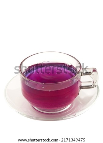 Butterfly pea tea in glass with coaster isolated on white background, blue hot drink. Butterfly pea tea changes its color from blue to purple by mixing lemon juice, Thai herbal tea.