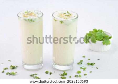 Buttermilk drink in glass cups on white background