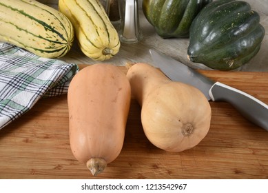 Butternut Squash On A Cutting Board With Acorn And Delicata Squash.