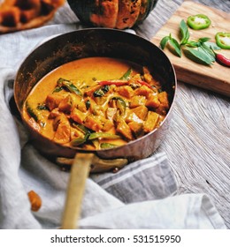 Butternut Squash/ Pumpkin In Authentic Thai Red Curry Coconut Sauce With Red And Green Chilies. Serve With Grilled Cashew Nut In A Butternut Squash Bowl. 