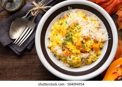 Butternut Squash Risotto With Thyme And Parmesan Cheese Against Dark Wooden Background. Overhead View