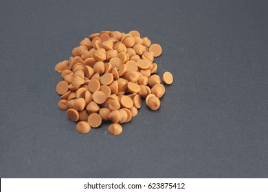 Butterscotch Chips Over Dark Grey Background