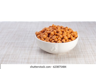 Butterscotch Chips In White Bowl  On Brown Cloth