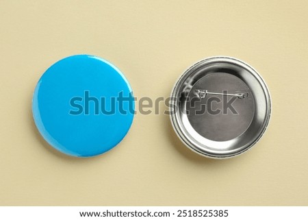 Button badges on beige background, flat lay. Mockup for design