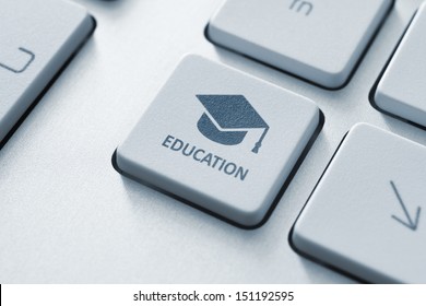 Button with graduation cap icon on a modern computer keyboard. Online education concept.