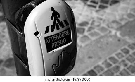 Button on traffic light for requesting to cross a street with written in Italian PLEASE WAIT, in detail