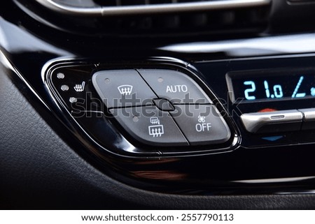 The button for raising the windows and the button for heating the seats in the car