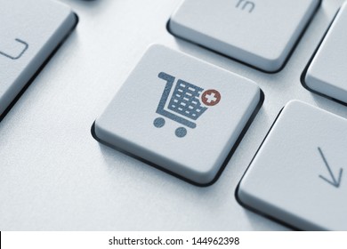 Button with shopping cart icon on a modern computer keyboard.