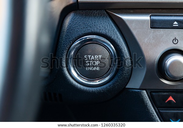 Button start and turn off the ignition of\
the car engine close-up on the dashboard, electric key, pressing\
drives the motor vehicle of modern\
design.