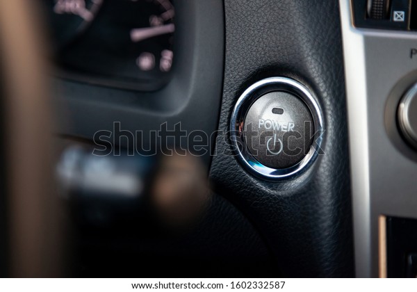Button
start and turn off the ignition of the car engine close-up on the
dashboard, electric key, of modern design with elements chrome on
the  beige interior panel. Auto service
industry.