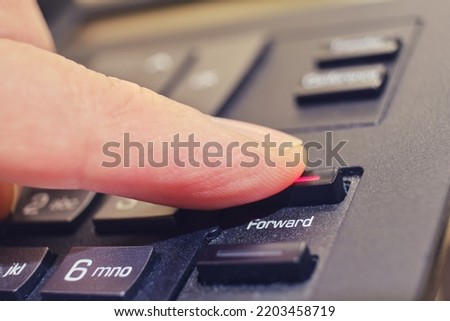 Button with text forward on a landline phone in the office, close-up