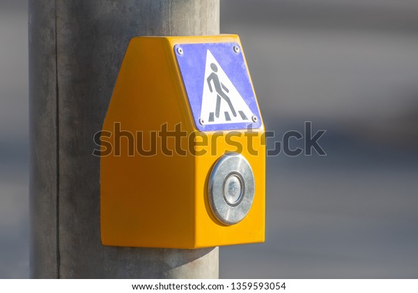 A button to turn on the green light at a\
pedestrian crossing on the\
highway