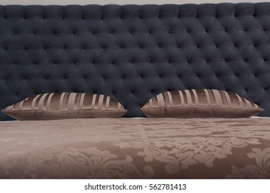 Buttoned Texture Of Dark Grey Color. Closeup Of Brown Pillows Represented On Bed In Bedroom Or Hotel Room. Texture Concept Of Luxurious Room.