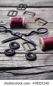 Buttons And Fasteners From Outdated Clothes On Wooden Background