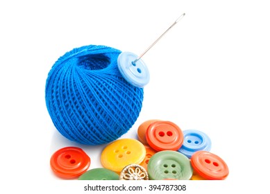 buttons, needle and thread on white background
