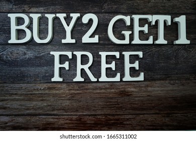 Buy 2 Get 1 Free with space copy on wooden background