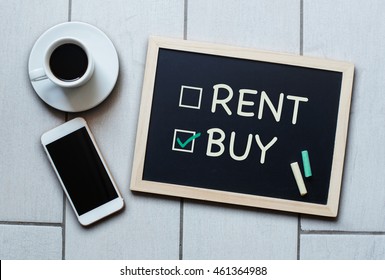 Buy Not Rent Blackboard Concept. Choosing Buying Over Renting With Coffee And Mobile Phone On Background