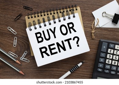 Buy or Rent. text on open notebook on wood background - Shutterstock ID 2103867455