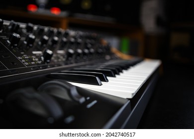Buy synthesizer piano in music store. Professional analog synth device with classic pianist keyboard and regulators. Sound recording studio equipment for sale 