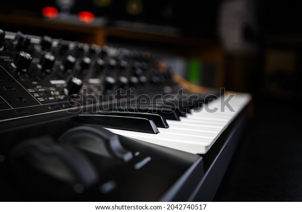 Buy synthesizer piano in music\
store. Professional analog synth device with classic pianist\
keyboard and regulators. Sound recording studio equipment for sale\
