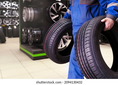 The Buyer Carries New Tires To The Exit Of The Tire Shop, Or The Tire Fitter Master Carries The Wheels For A Seasonal Change Of Tire Wheels For Safe Driving In Winter Or Summer