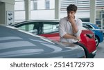 Buyer client Caucasian man businessman in automobile salon rental service choose buying car touching transport hood modern vehicle pensive thoughtful guy thinking choosing in store decision pondering