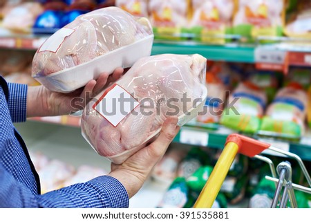 Buyer man chooses chicken meat in a shop