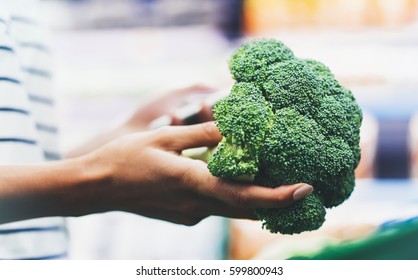 The buyer weighs the green fresh broccoli close up, woman shopping healthy food in supermarket blur background, female hands buy nature products in store grocery  - Powered by Shutterstock