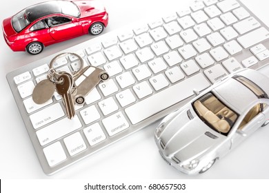 Buying Car Online. Car Keys And Toy Car On Keyboard On White Background Top View