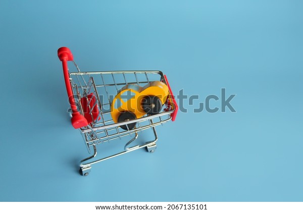 Buying car, car sales and car ownership concept.\
Cars in shopping trolley