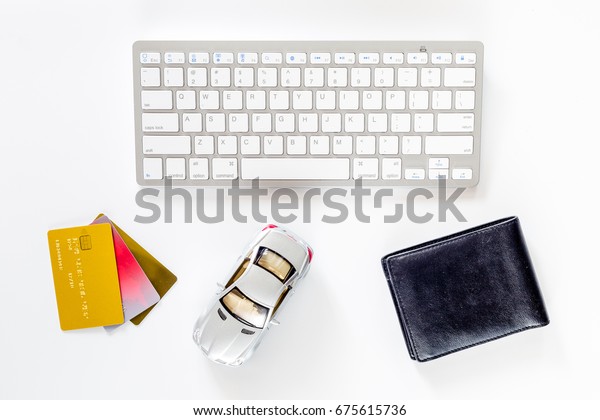 Buying car. Toy car, bank card and\
wallet near keyboard on white background top\
view