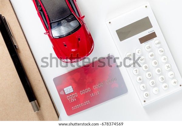Buying car. Toy car and bank card on white\
background top view