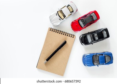 Buying Car. Toy Cars On White Background Top View Copyspace