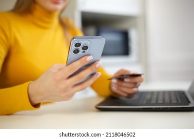 Buying With Credit Card Online. Woman Making A Purchase In Internet Store With Modern Mobile Phone And Bank Card. Young Female Makes Money Transfer With Smartphone App. Online Shopping At Home Concept