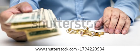 Buying gold jewelry, us dollars and hand of a businessman, panorama, bodypart hands