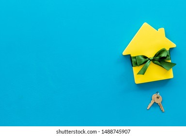 Buying A New House Concept With House Figure And Keys On Blue Background Top View Space For Text